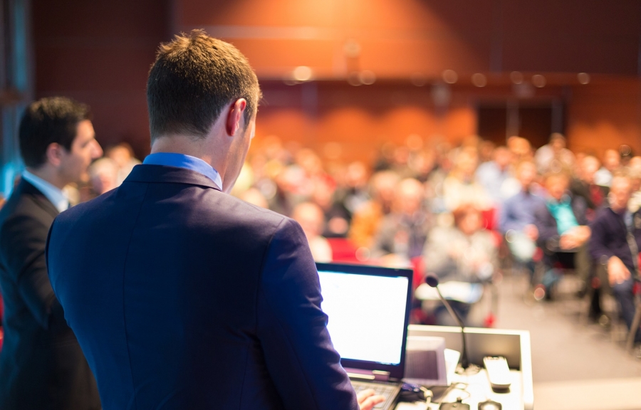 Man giving a presentation to a group of business people at a conference or seminar