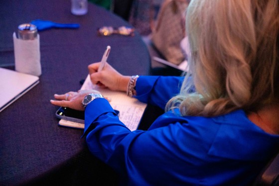 A woman writing in a notebook at Cvent CONNECT 2023 in National Harbor, Maryland.