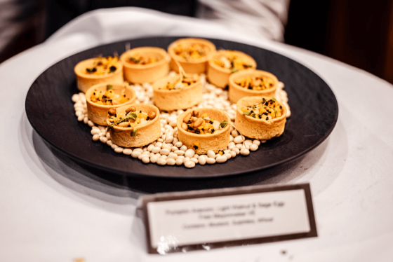 Plate of white beans and tarts with a menu card in front of it on a table