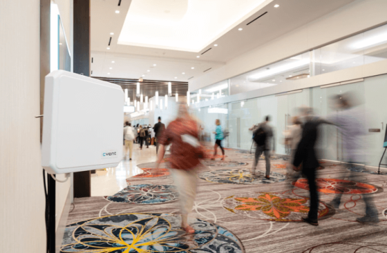 TShow3 - A white object with "vent" text in a hallway with people and glass architecture.