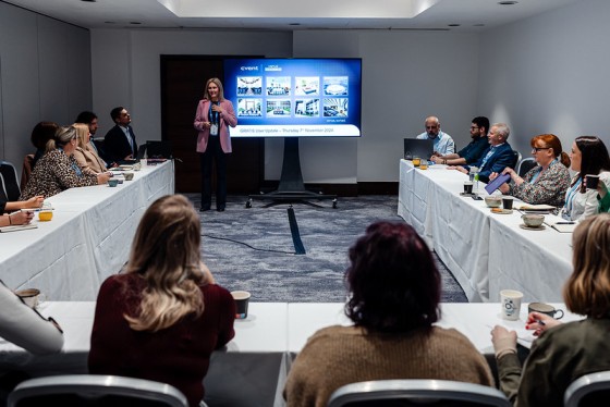 Woman standing in front of a screen giving a presentation to a focus group.