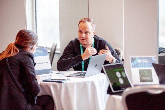Two people sitting and having a discussion at Cvent Connect Europe 2024 with laptops on the table.