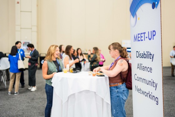 Networking Meet-Up at Cvent CONNECT 2024 with a sign that reads "Meet-Up Disability Alliance Community Networking".