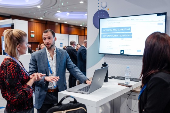 A booth at Cvent CONNECT Europe 2024 with a laptop and two women in conversation.