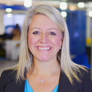 A headshot of Stacey Fontenot wearing a black blazer and a blue shirt with a necklace.