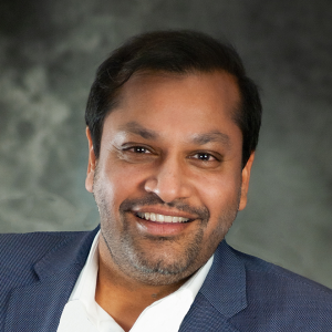 Reggie Aggarwal, CEO of Cvent, wearing a blue blazer and a white shirt, smiling for the camera.