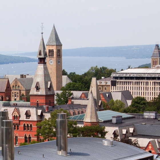 Cornell University with the clock tower and the lake in the background, and the clear sky above.