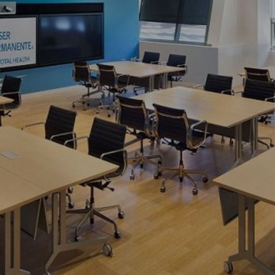 A room with tables, chairs, and a sign that says Kaiser Permanente Center for Total Health.