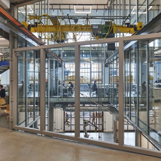 Autodesk case study background image of a glass door with people sitting at tables in an open space.
