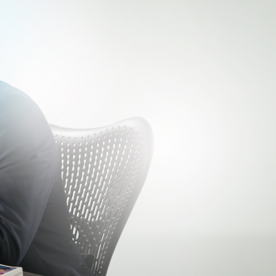 A man in business attire talking on the phone and using a laptop.