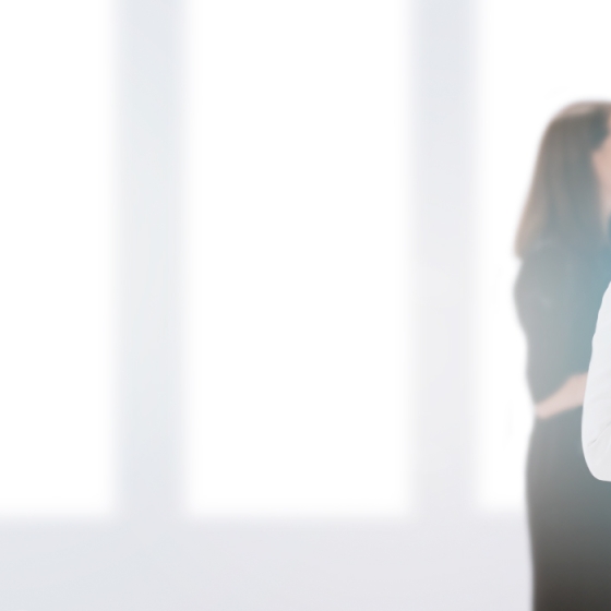 Business people having a meeting in a modern office with a blurred background of colleagues in the background.