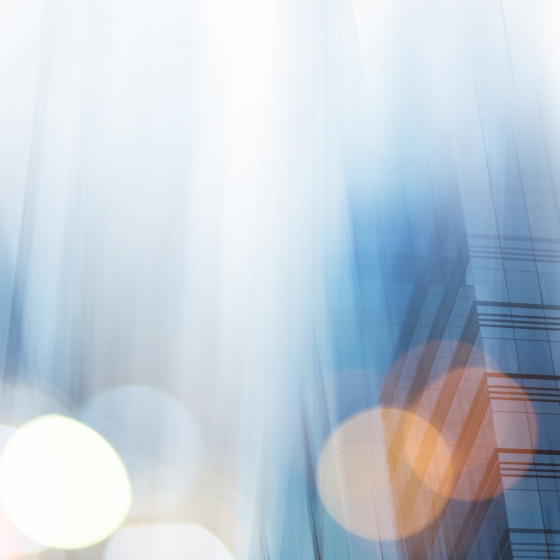 Modern building with blurred lights and reflections creating an abstract, vibrant cityscape view.