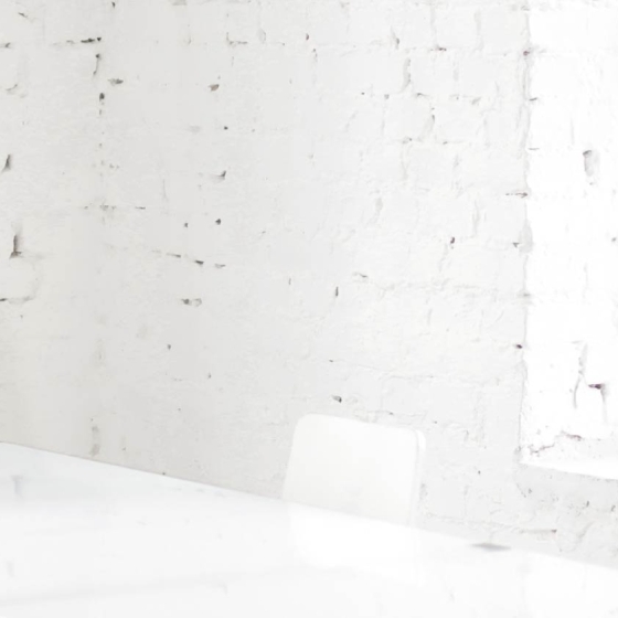Woman working from home in an office with a laptop and smiling at the camera.