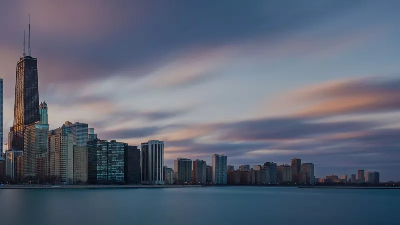 A cityscape with high-rise buildings and a body of water, reflecting the vibrant ambiance of Chicago.