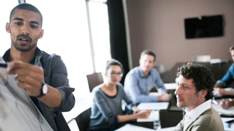 A man is giving a presentation to a group of people in a meeting room about GDPR.