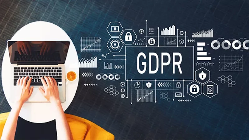 Person types on laptop, with GDPR, icons, and graphs on a blue background.