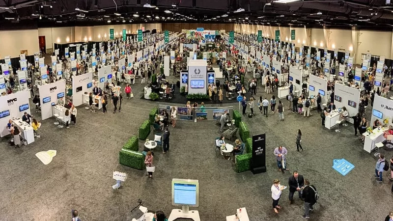 A bird's eye view of a large conference room with a lot of people and booths.