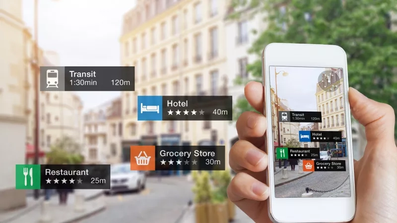 A hand holding a smartphone with the Google Maps app open showing different places and their travel times.