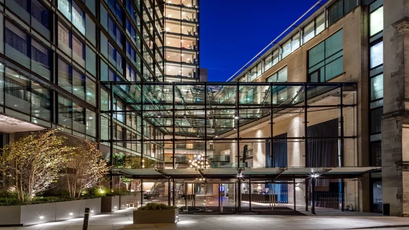 Exterior shot of Edwardian Manchester, A Radisson Collection Hotel with the entrance lit up at night.