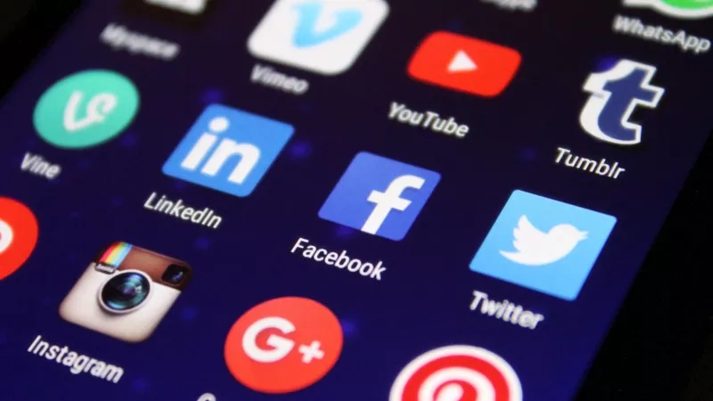 A smartphone screen with various social media app icons displayed, including Facebook, Twitter, and Instagram.