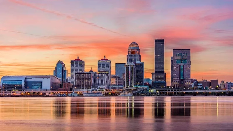 The skyline of Louisville with the Galt House in the foreground at sunset in Kentucky.