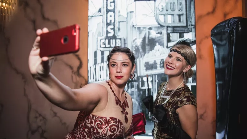 Two ladies taking selfies at the Great Gatsby themed party at The Chandelier Club in Las Vegas.