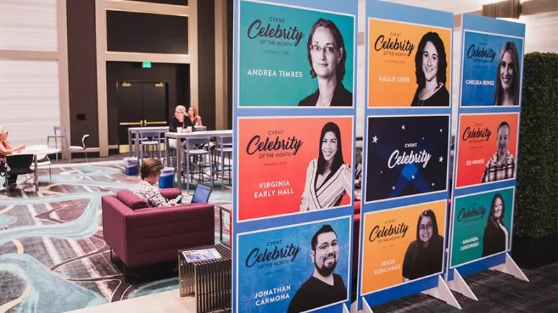 Celebrity Lounge with 12 posters of celebrities in the middle of the room, 3 people around.