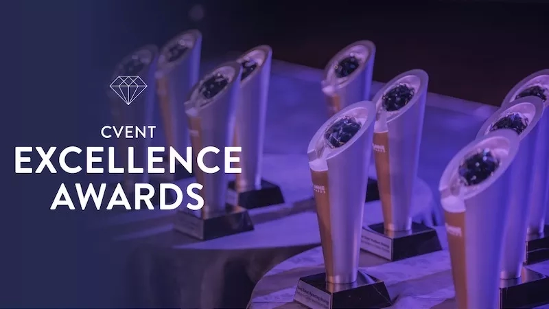 Multiple Cvent Excellence Awards on a table with blue background and the words "Cvent Excellence Awards".