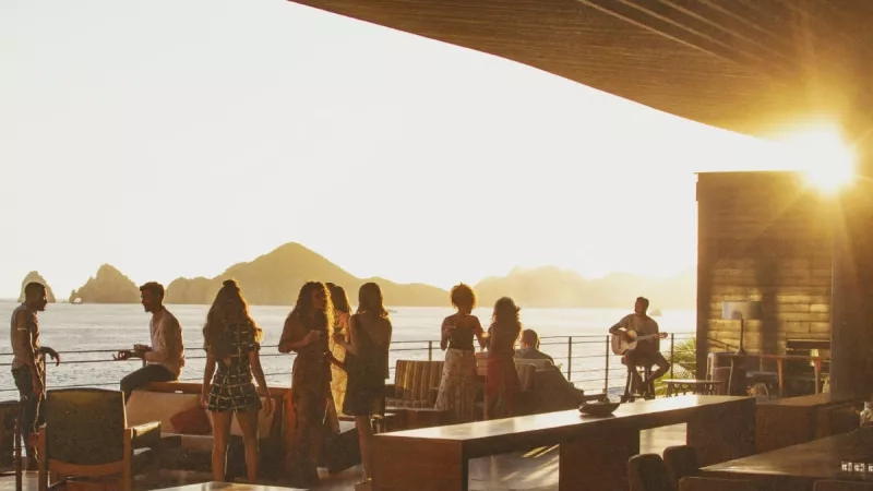 Group of people having drinks in a bar overlooking the ocean in Cabo San Lucas.