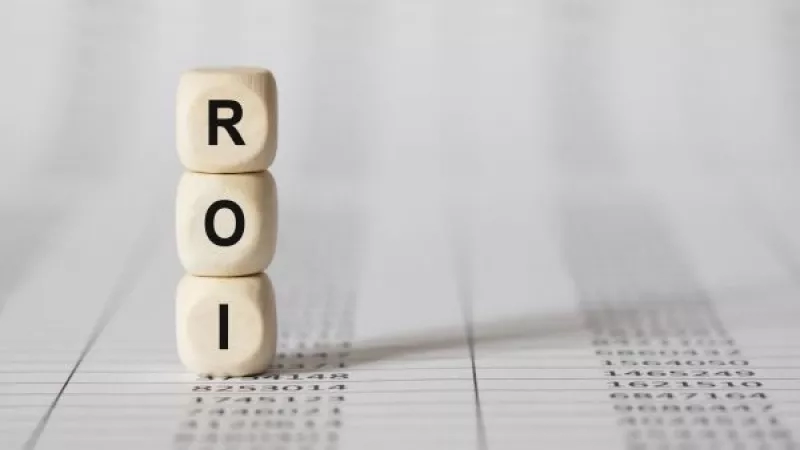 Wooden blocks with ROI letters on top of a white sheet with numbers.