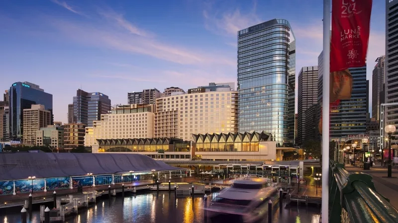 Hyatt Regency Sydney exterior view showing the hotel in the city skyline at sunset.