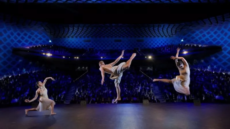 Three ballet dancers performing on stage in front of an audience at ICC Sydney.