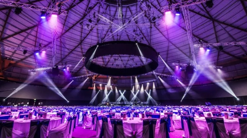 Large event space with tables, chairs, and purple lighting at Sydney Olympic Park.