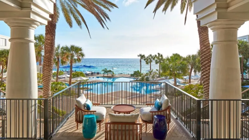 Balcony view of swimming pool, beach, and ocean at The Ritz-Carlton Naples, Tiburón.