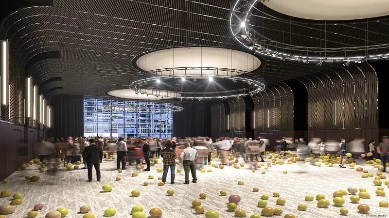 People walk around a large hall filled with yellow and pink balls at the Grand Hyatt Seoul.