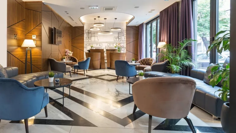 view of luxury hotel lobby with chairs and plants