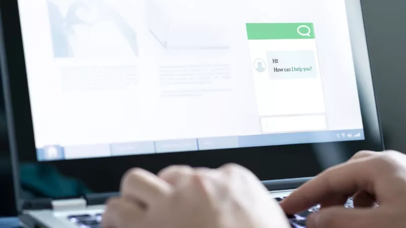 Person talking to an artificial intelligence chatbot on a laptop.