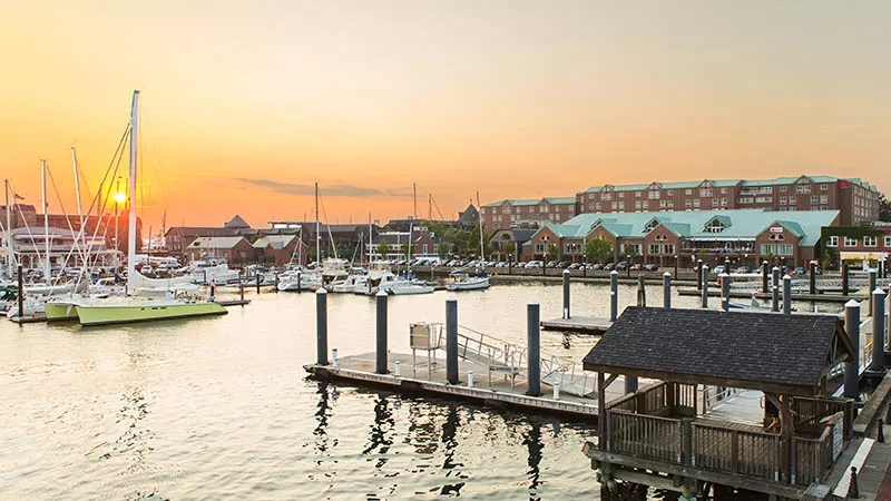 Boats, a dock, and buildings under a sunset sky, all part of the Discover Newport experience.