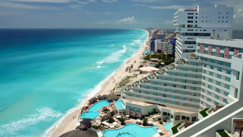 Aerial view of a resort in Mexico with pool, beach, and ocean, perfect for a family vacation.