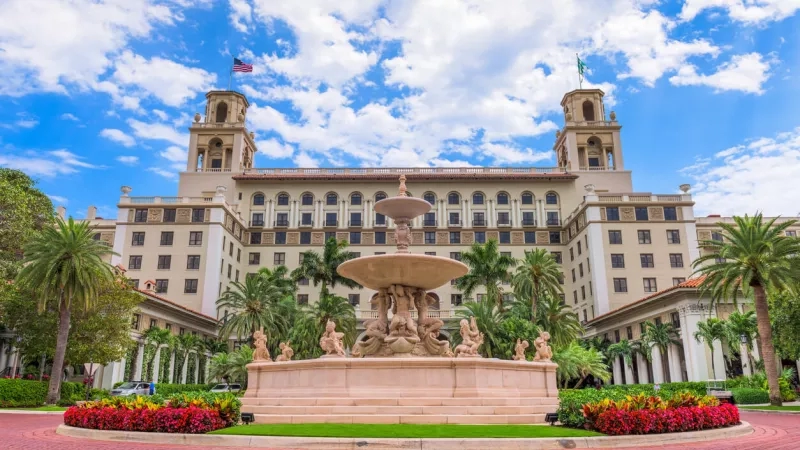 The Breakers Palm Beach hotel in Florida with fountain, architecture, landscaping, and ambiance in blue sky and clouds.