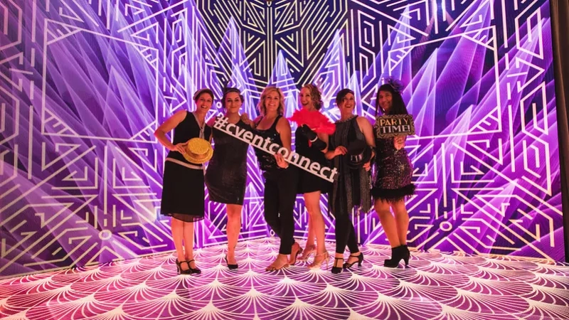 Group of women in a row posing for the camera with an art deco theme.