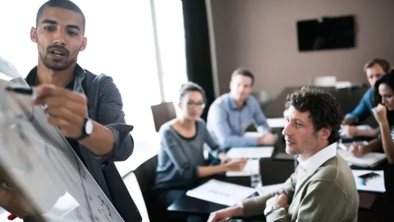 Man giving a presentation on bundles to a group of people in a conference room.
