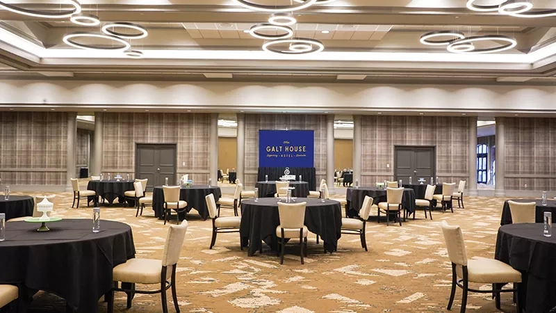 Many round tables are set up in a large banquet hall at the Galt House Hotel.