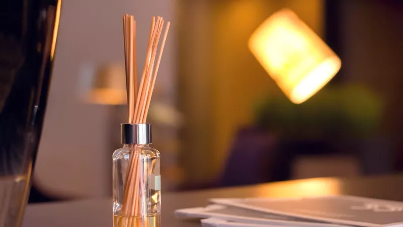 Scent diffuser on table in luxury hotel room with warm ambiance and elegant decor.
