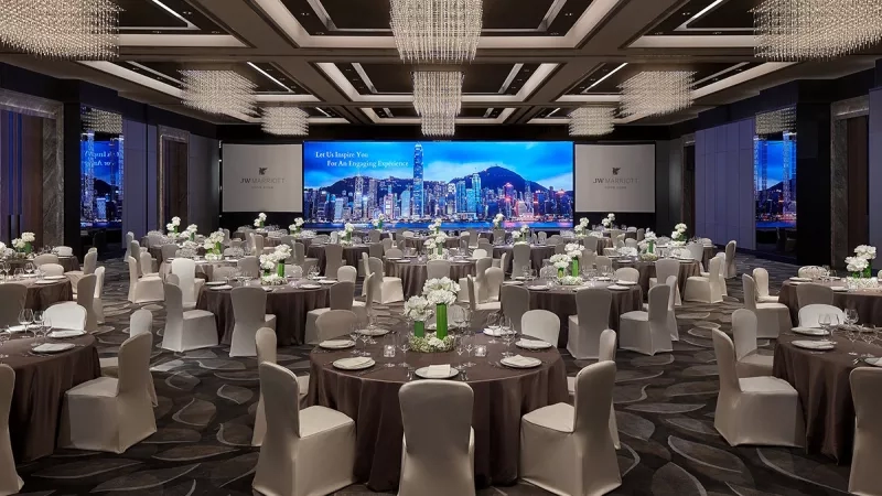JW Marriott Hotel Hong Kong's ballroom for corporate dinner, with a cityscape on the screen and elegant decor.