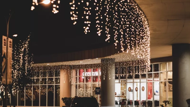 Nighttime scene of Greenway shopping center, illuminated by lights and greenery, creating a vibrant ambiance.