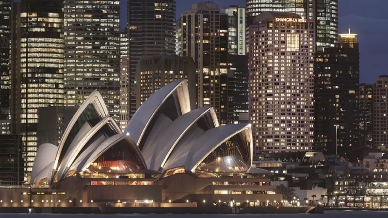 The illuminated Sydney Opera House and Shangri-La Hotel stand out against the night sky in this cityscape.