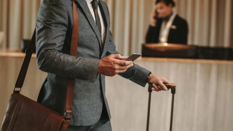 Man using hotel mobile check-in on phone in lobby at The Ritz-Carlton, Sarasota.