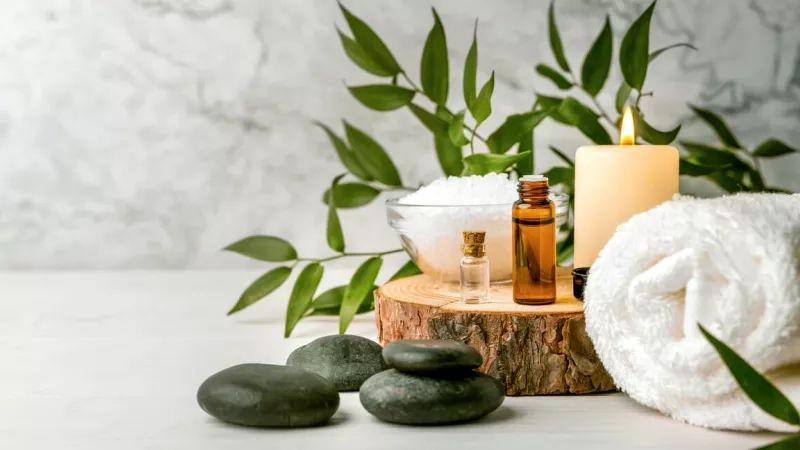 Massage stones, essential oils, and sea salt set up for spa marketing.