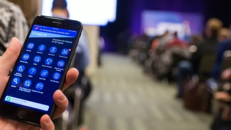 Event mobile app in hand at The Marketing Nation Summit 2017 with an out of focus audience in the background.
